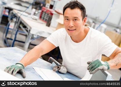 Asian worker in production plant on the factory floor. portrait of asian worker in production plant working on the factory floor