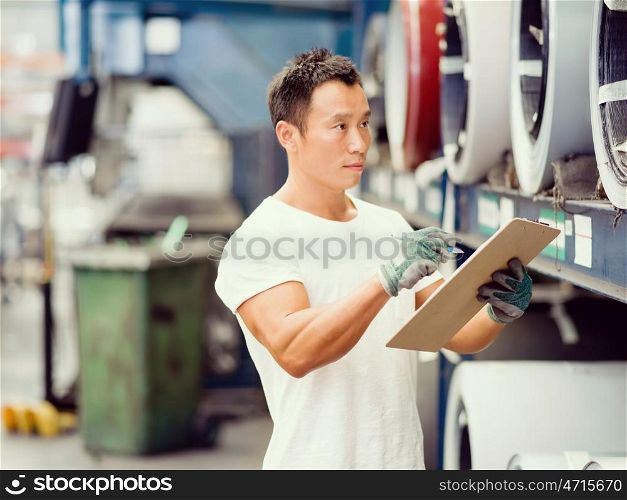 Asian worker in production plant on the factory floor. portrait of asian worker in production plant working on the factory floor