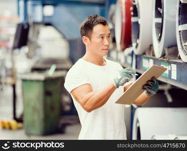 Asian worker in production plant on the factory floor. portrait of asian worker in production plant working on the factory floor