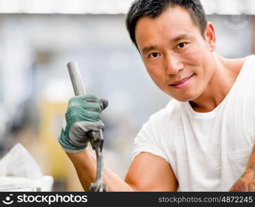 Asian worker in production plant on the factory floor. portrait of asian worker in production plant working on the factory floor