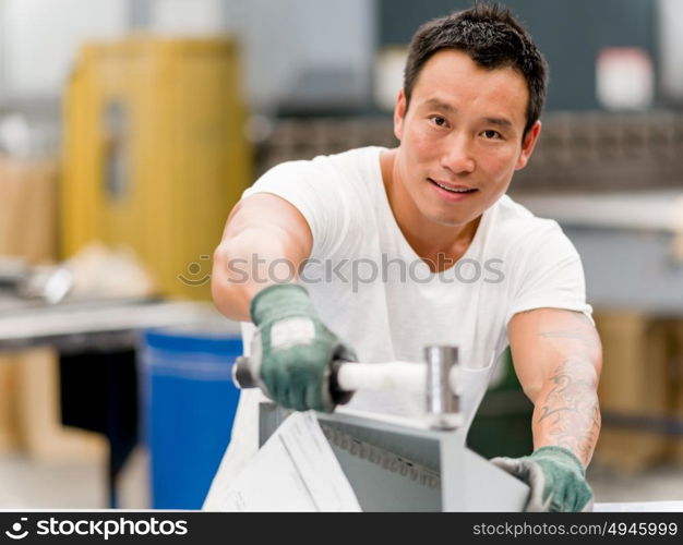 Asian worker in production plant on the factory floor. portrait of asian worker in production plant working on the factory floor