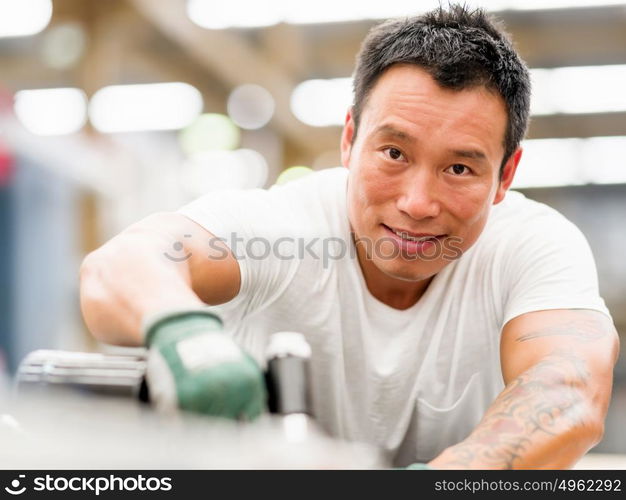 Asian worker in production plant on the factory floor. portrait of asian worker in production plant working on the factory floor