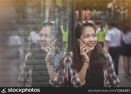 asian yonger woman toothy smiling face talking on mobile phone happiness emotion