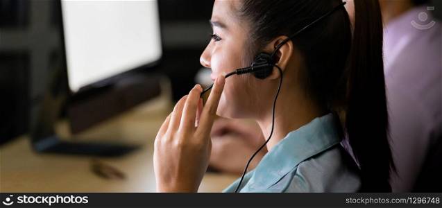 Asian young adult confidence operator colleague team with headsets working in a call center at night as customer service and technical support. Using as Late night hard working 24 Hr. 7 Days concept.