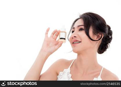 Asian young beautiful woman smiling she&rsquo;s holding bottle serum hair or skin care near face for present product isolated on over white background, Beauty salon concept