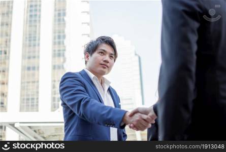 Asian young business man shaking his hand to make a successful deal or agreement