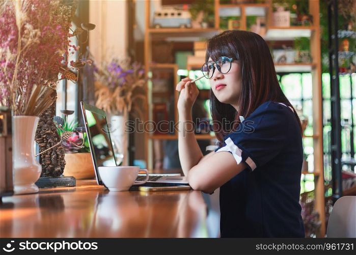 Asian young business woman working make a note of something making notes on in coffee shop like the background.