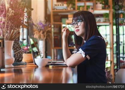 Asian young business woman working make a note of something making notes on in coffee shop like the background.