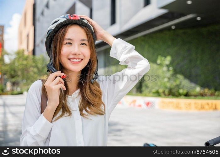 Asian young businesswoman putting biking helmet prepared cyclists go to work, Close up beautiful woman wearing helmet exercise outdoors, Transport Save Energy concept