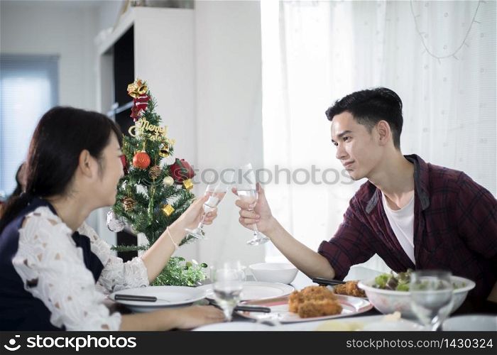 Asian young couple enjoying a romantic dinner evening drinks while sitting at the dinning table on the kitchen together,soft focus