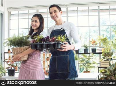Asian young couple spending time together in holiday and gardening plants at home. Nature, Hobby, Interior and Lover Concept.