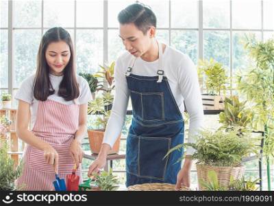 Asian young couple spending time together in holiday and gardening plants at home. Nature, Hobby, Interior and Lover Concept.