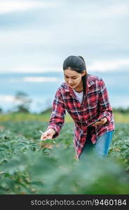 Asian young female farmer with a tablet in her hands examines the green field. Modern technologies in agriculture management and agribusiness concept.