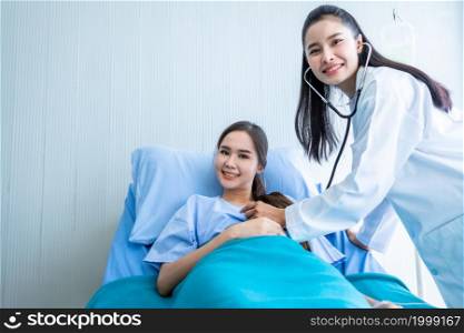 Asian young female patient on bed while doctor hands of checking examining his pulse for record the treatment results with smiley face very good symptom in hospital background.
