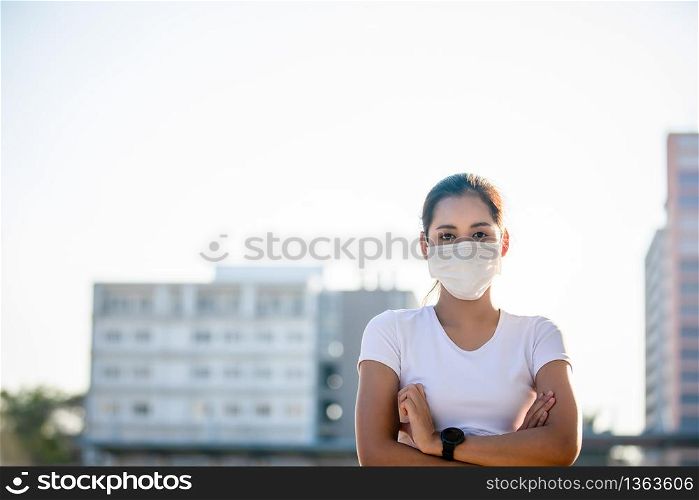 Asian Young fitness sport woman running and she wears a mask for protective Dust and pollution and protection flu virus, influenza, coronavirus on city