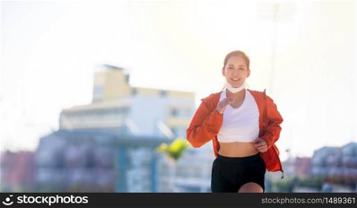 Asian Young fitness sport woman running and she wears a mask for protective Dust and pollution and protection flu virus, influenza, coronavirus on city