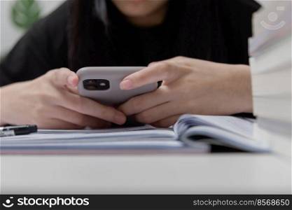 Asian young girl use a mobile smart phone to study education online at home.