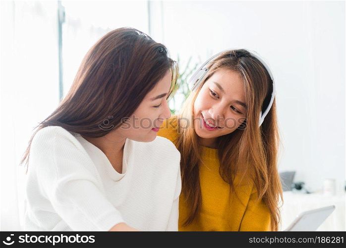 Asian young lesbian couple listening to music together in a happy moment of love in the bedroom. LGBT couple listening to music in a love emotion. LGBT love couple in bedroom concept.