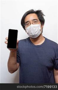 Asian young man in casual wearing surgical medical mask to protect COVID-19 using smart mobile phone isolated on white Health care concept.Wuhan coronavirus (COVID-19) outbreak prevention in public area.