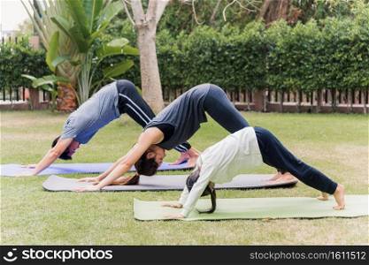 Asian young mother, father practicing doing yoga exercises with child daughter outdoors in meditate pose together in nature a field garden park, family kid sport and exercises for healthy lifestyle