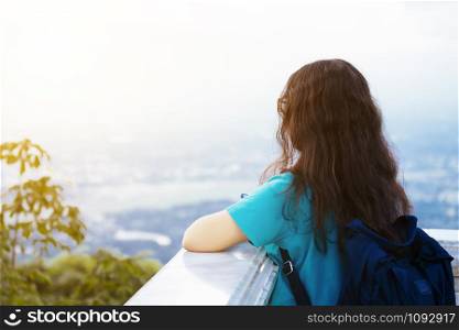 Asian young woman blue dress carry bag travelers looking with at admiring the view cityscape mountain range background.