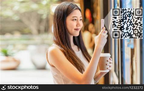 Asian young woman hand using smart mobile phone scanning bar code and QR code to movie tickets machine for buy and get the coupon in department store,lifestyle and leisure, technology scanner concept