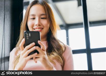 Asian young woman hands holding mobile phone at cafe coffee shop, Happy beautiful female typing text message on smart phone device and enjoyment lifestyle with social networking media