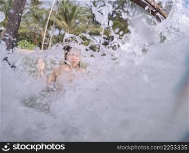 Asian young woman having fun in the sea. Stop shot wave splashing.