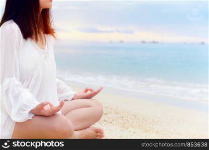 Asian young woman practice yoga on the beach near the sea under sunlight at sunrise, Relaxation for health in the midst of nature with happiness and peace, blank for the background. Asian young woman practicing yoga on the beach