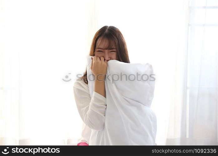 Asian young woman smiling on white bedroom