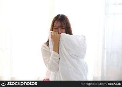 Asian young woman smiling on white bedroom