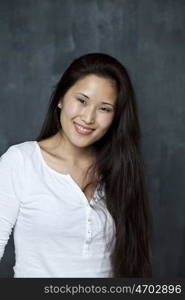 Asian young woman standing by wall