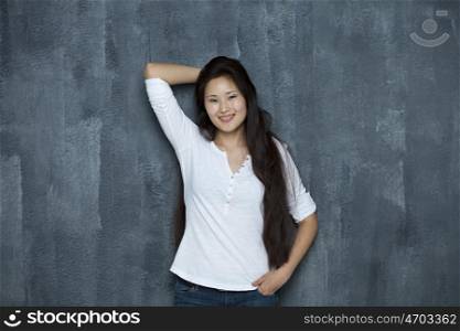 Asian young woman standing by wall