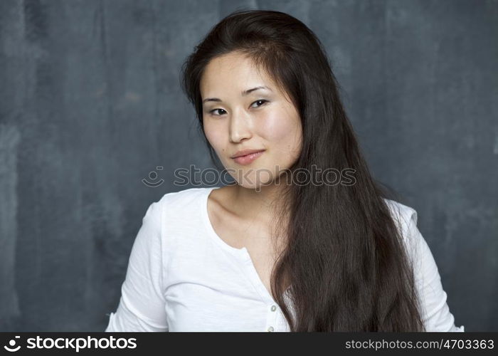 Asian young woman standing by wall