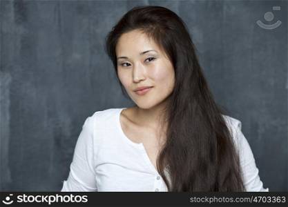 Asian young woman standing by wall