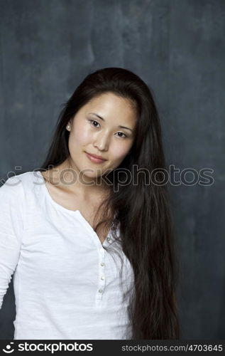 Asian young woman standing by wall