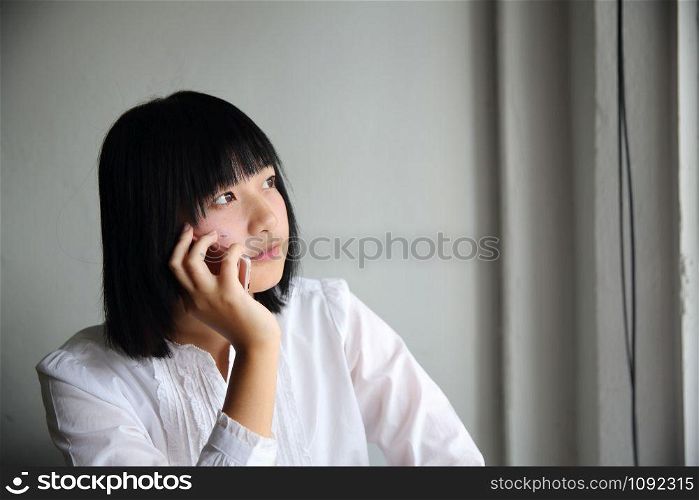 Asian young woman talking with smartphone portrait in coffee shop cafe