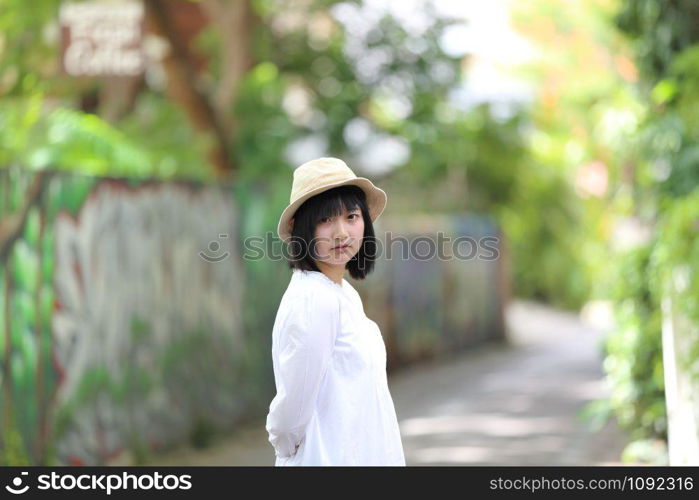 Asian young woman thinking and looking portrait with green tree background