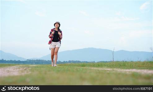 Asian young woman tourist backpack walk travel in the nature forest. Woman tourist walking in the nature on background mountain view.