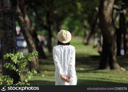 Asian young woman walk looking and traveling concept portrait with green tree background