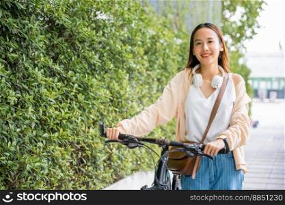 Asian young woman walking alongside with bicycle on summer in park countryside outdoor, Happy female smiling walk down the street with her bike on city road, ECO environment, healthy holiday travel