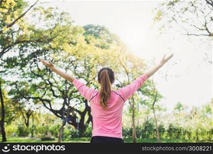 Asian young woman warm up the body stretching before morning exercise and yoga in the park under warm light morning. Healthy young asian woman exercising at park. Woman exercise outdoor concept.