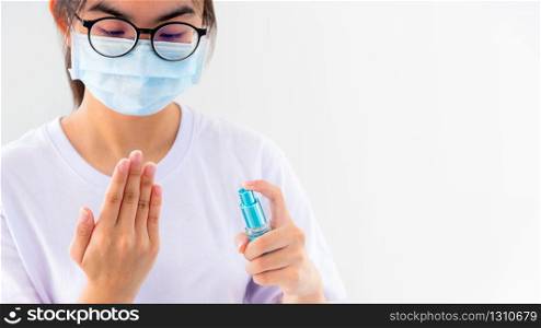 Asian young woman wears mask protect wash hand cleaning with alcohol spray stop coronavirus outbreak or prevent the spread of the Covid 19 virus isolated on white background, Good hygiene concept 16:9. Hand cleaning with alcohol spray