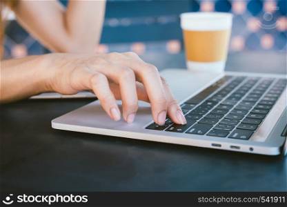 Asian young women in smart casual clothes working sending email on laptop and drinking coffee while sitting in cafe. Lifestyle women communication and working in coffee shop concept.
