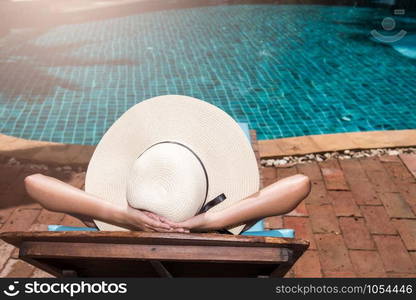 Asian young Women relaxing sleep poolside at luxury swimming pool blue water