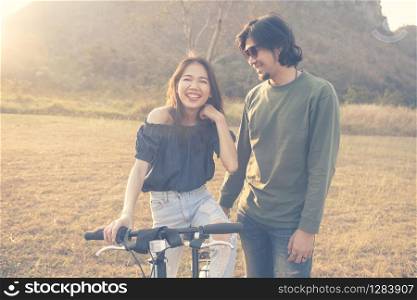asian younger man and woman laughing and relaxing outdoor
