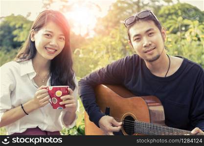 asian younger man and woman playing guitar with happiness emotion