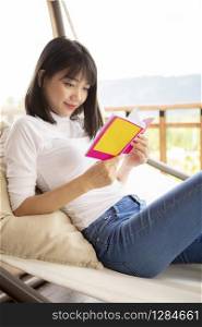 asian younger woman ralaxing reading a book