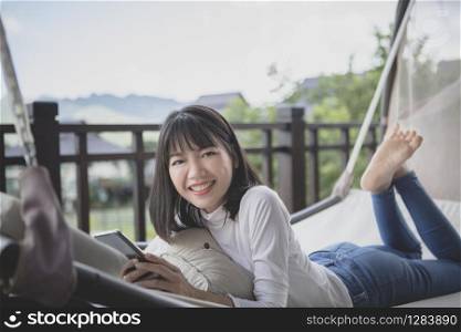 asian younger woman relaxing with toothy smiling face on a cradle