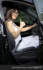 asian younger woman sitting on suv car driving seat toothy smiling face with self confidence